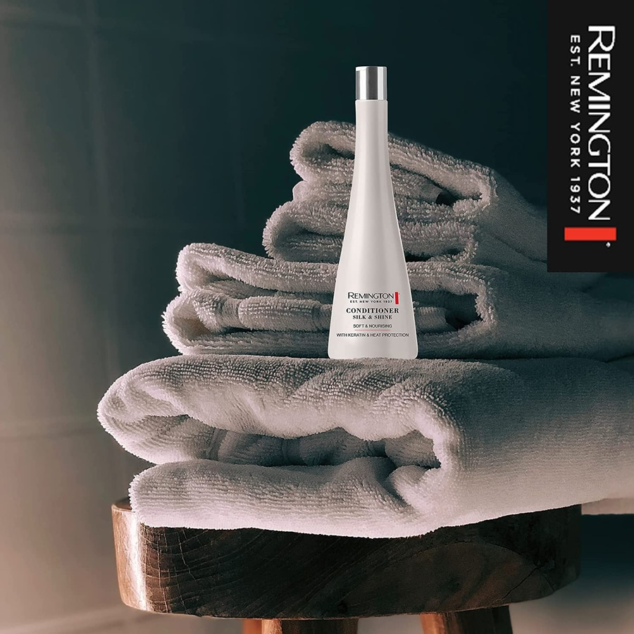 Produkt von Remington auf Handtüchern. Conditioner Silk & Shine. Weich und pflegend.