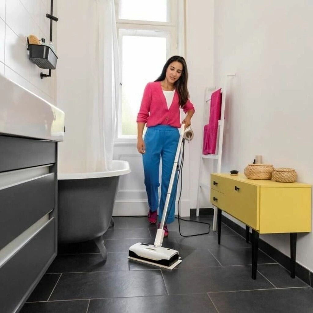 Eine Frau putzt mit einem Wischmopp den Badezimmerboden.