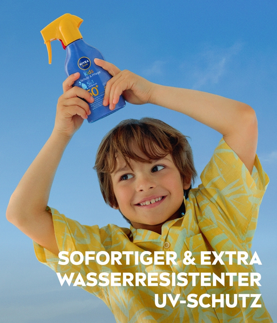 Ein Junge hält eine Sonnencreme von Nivea über seinen Kopf.