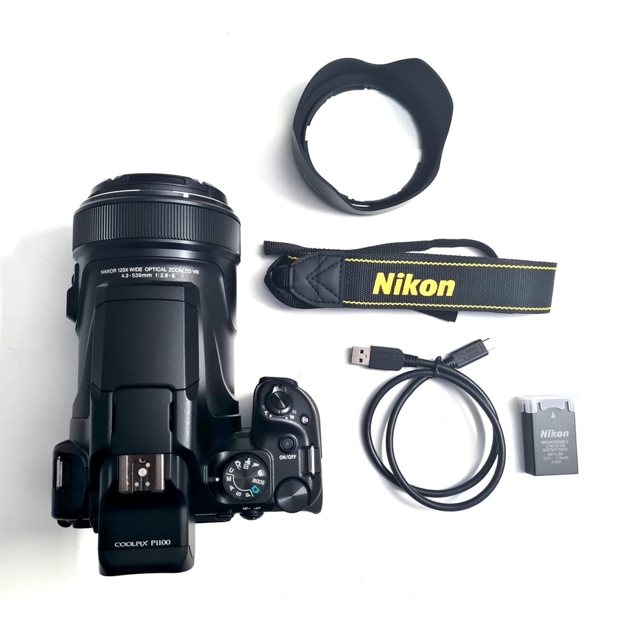 Nikon Kamera Zubehör mit Kamera, Objektivhaube, Tragegurt, Kabel und Akku