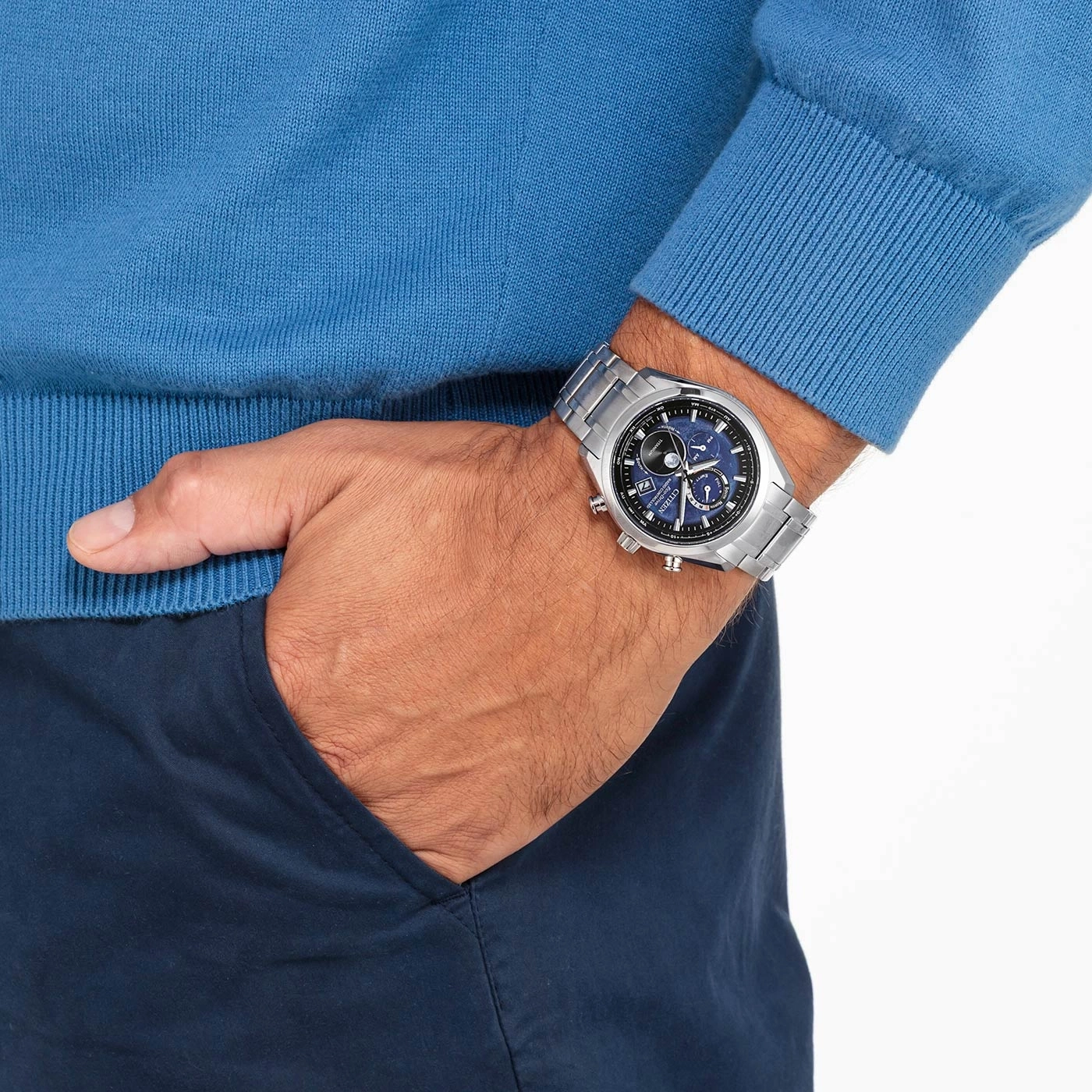 Ein Mann mit einer blauen Strickjacke und einer Uhr an seinem Handgelenk.