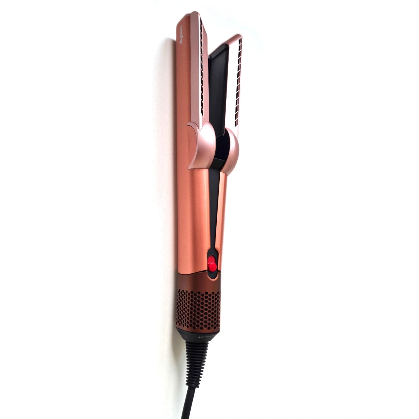 Ein roségoldener Dyson Haarglätter mit rotem Knopf und Lüftungsschlitzen.