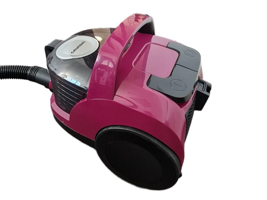 Ein pinker Grundig Staubsauger mit schwarzem Schlauch und Rädern.