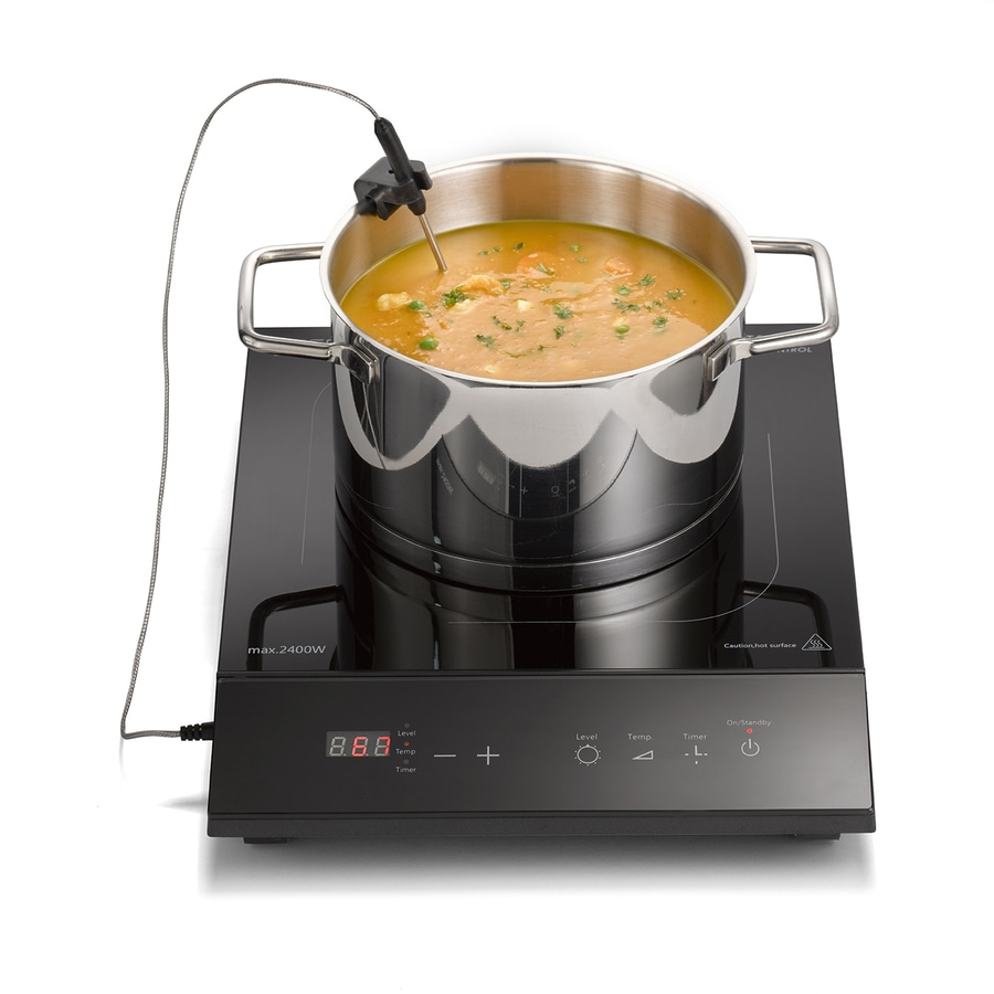 Eine Kochplatte mit einem Topf Suppe und einem Thermometer.