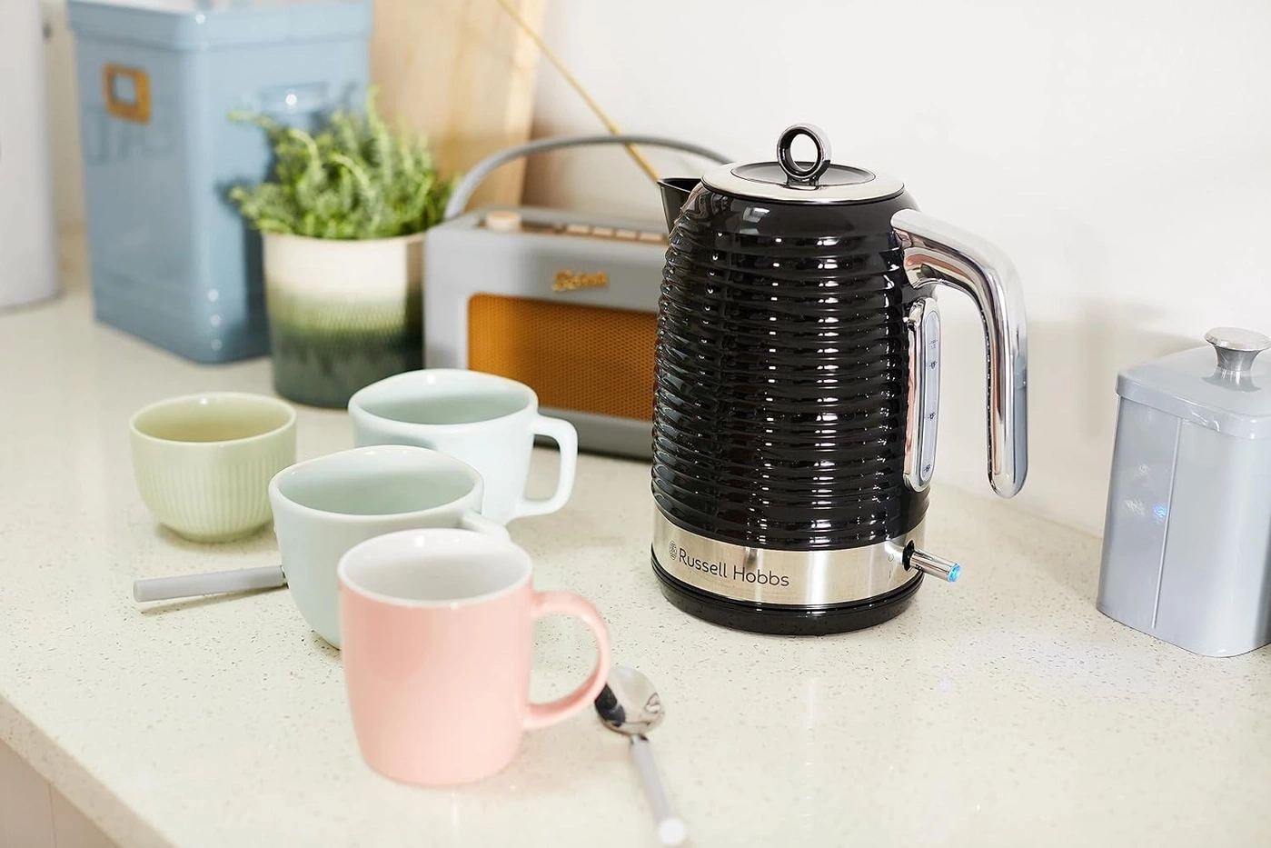 Schwarzer Wasserkocher mit Tassen auf einer Küchenarbeitsplatte, Russell Hobbs.