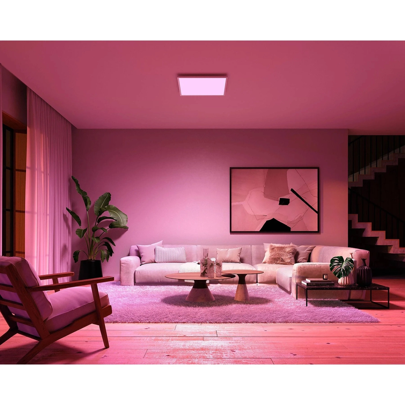 Wohnzimmer mit rosa Beleuchtung und modernen Möbeln.