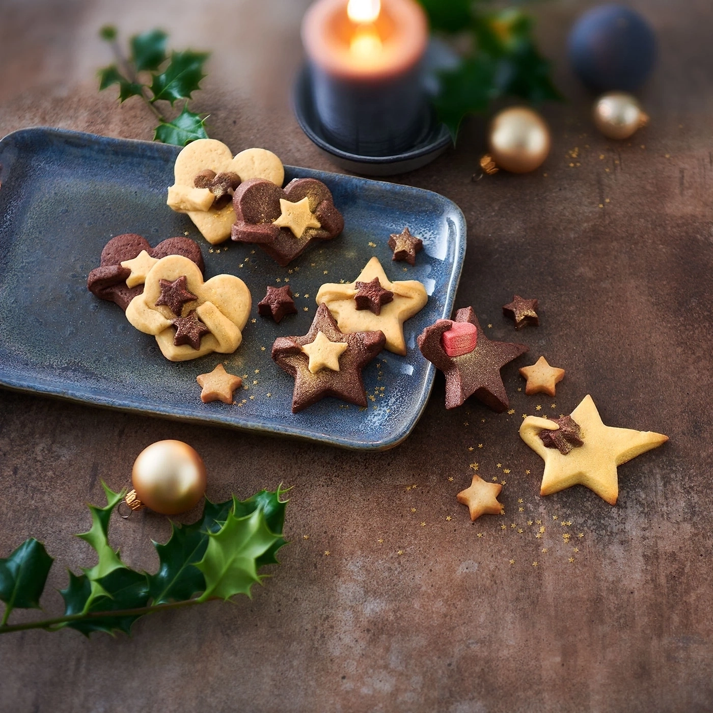 Weihnachtsplätzchen auf einem Teller mit Kerze und Dekoration