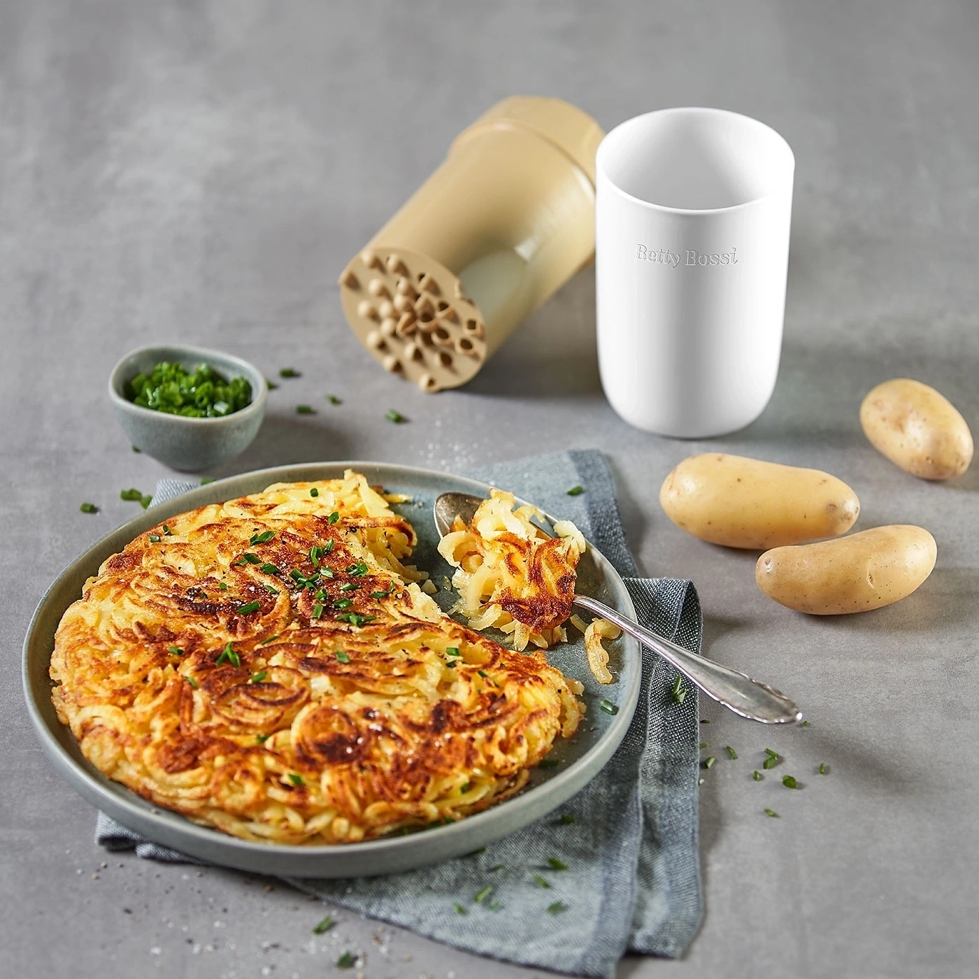 Kartoffelgericht mit Zwiebeln, Kräutern und Kartoffelschneider, Betty Bossi