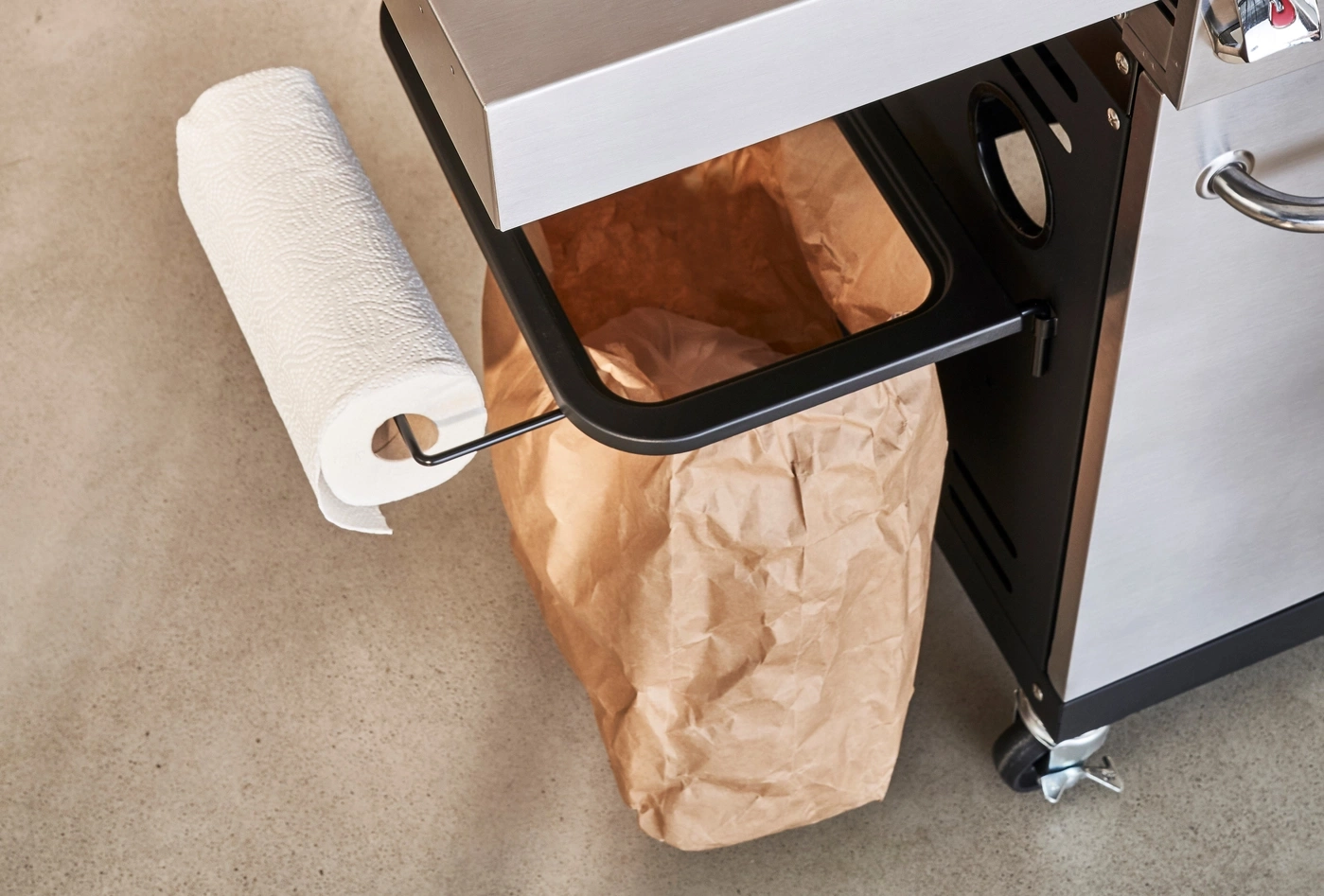 Papierhandtuchrolle und Papiertüte an einem Grillwagen auf Betonboden
