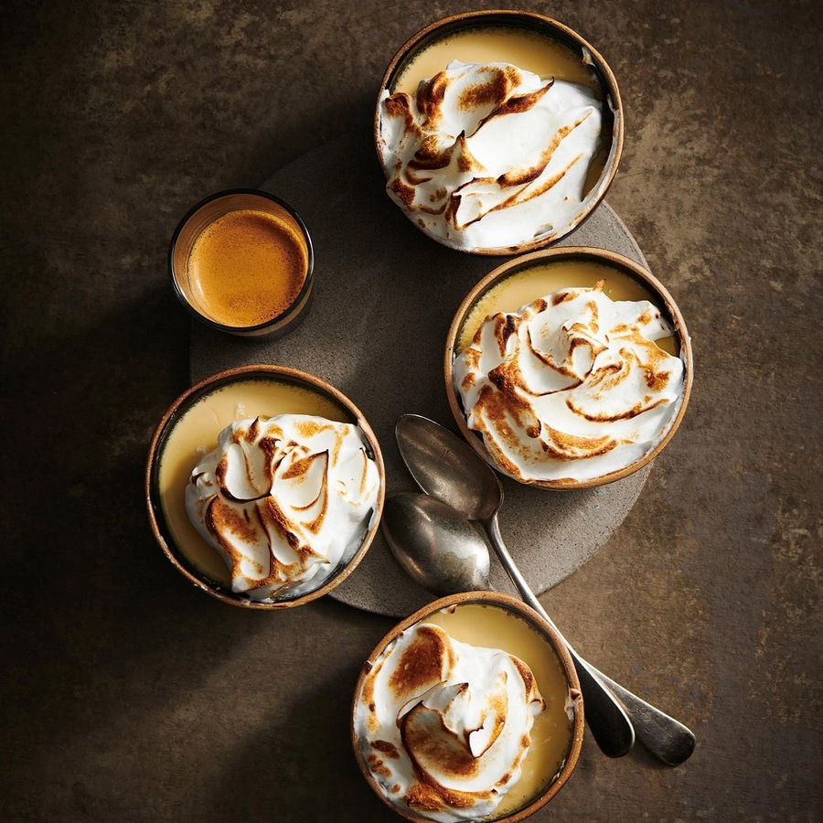 Desserts mit Baiserhaube, Espresso, Löffel auf grauem Untergrund
