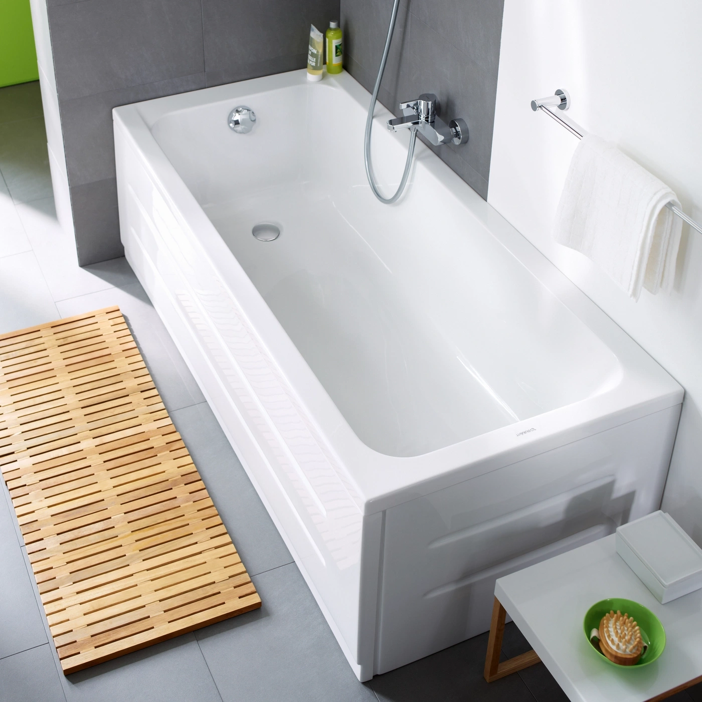 Badewanne mit Holzmatte und Zubehör. Badezimmer mit weißer Badewanne.