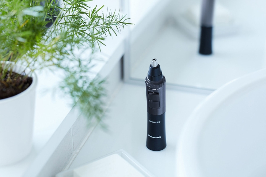 Nasenhaartrimmer von Panasonic auf weißer Oberfläche mit Pflanze und Spiegelung