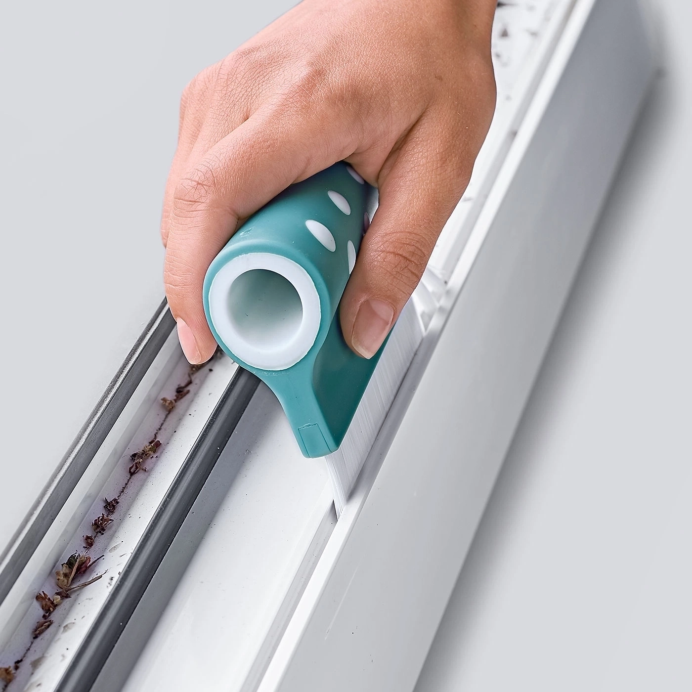 Person reinigt Fensterrahmen mit einem speziellen Reinigungsgerät, Nahaufnahme