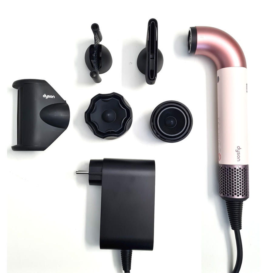 Dyson Haartrockner mit Zubehör auf weißem Hintergrund. Haartrockner, Aufsätze und Ladegerät.