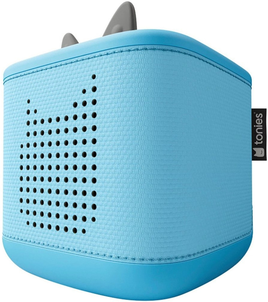Eine blaue Toniebox mit Lautsprecherlöchern in Form eines Gesichts und Ohren. Auf der rechten Seite ist das Tonies-Logo auf einem schwarzen Etikett.