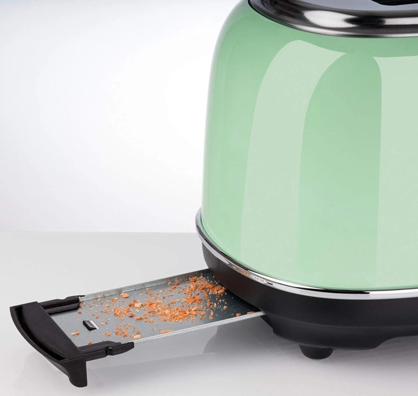 Grüner Toaster mit Krümeln in der Krümelschublade, Nahaufnahme, Küche
