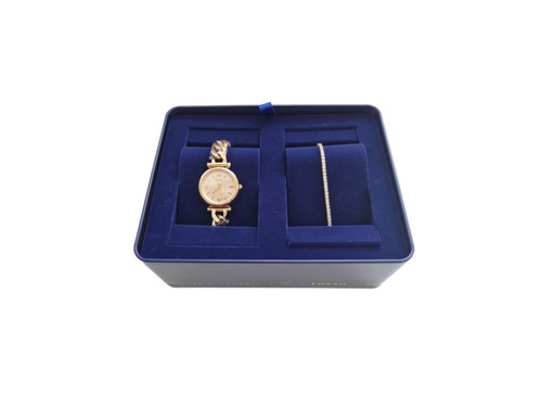 Eine goldene Uhr und ein Armband liegen in einer blauen Box