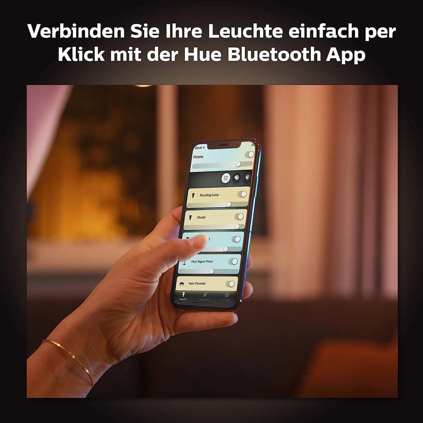 Eine Hand hält ein Smartphone, das die Hue Bluetooth App anzeigt, mit dem Titel "Verbinden Sie Ihre Leuchte einfach per Klick mit der Hue Bluetooth App".