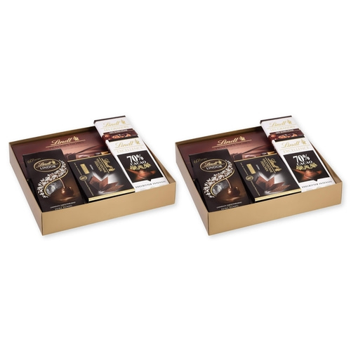 Zwei goldene Geschenkboxen mit Lindt Schokoladen, eine links und eine rechts.