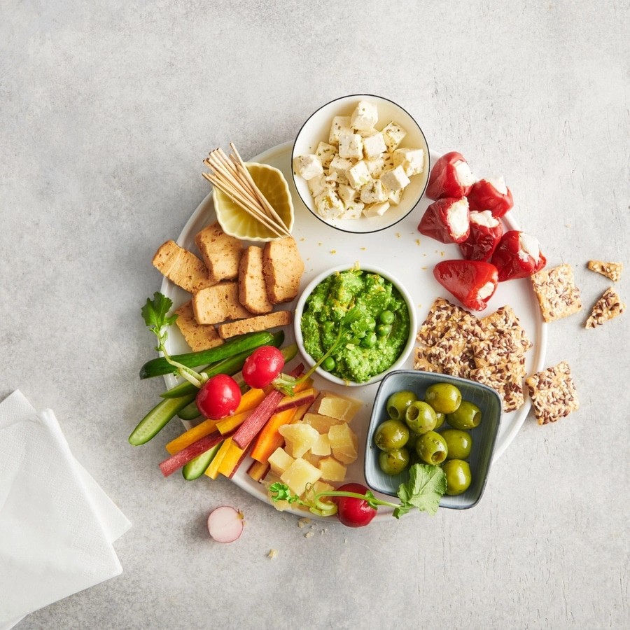 Käse, Oliven, Gemüse und Cracker auf einem Teller. Leckeres Essen.