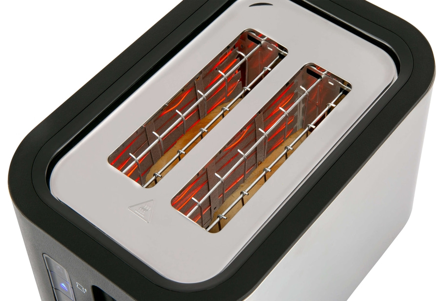 Nahaufnahme eines Toasters mit zwei Schlitzen und Heizdrähten, die glühen