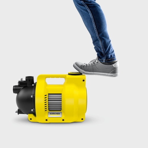Gelbe Pumpe mit Fuß. Person steht auf der Pumpe. Kärcher Logo.