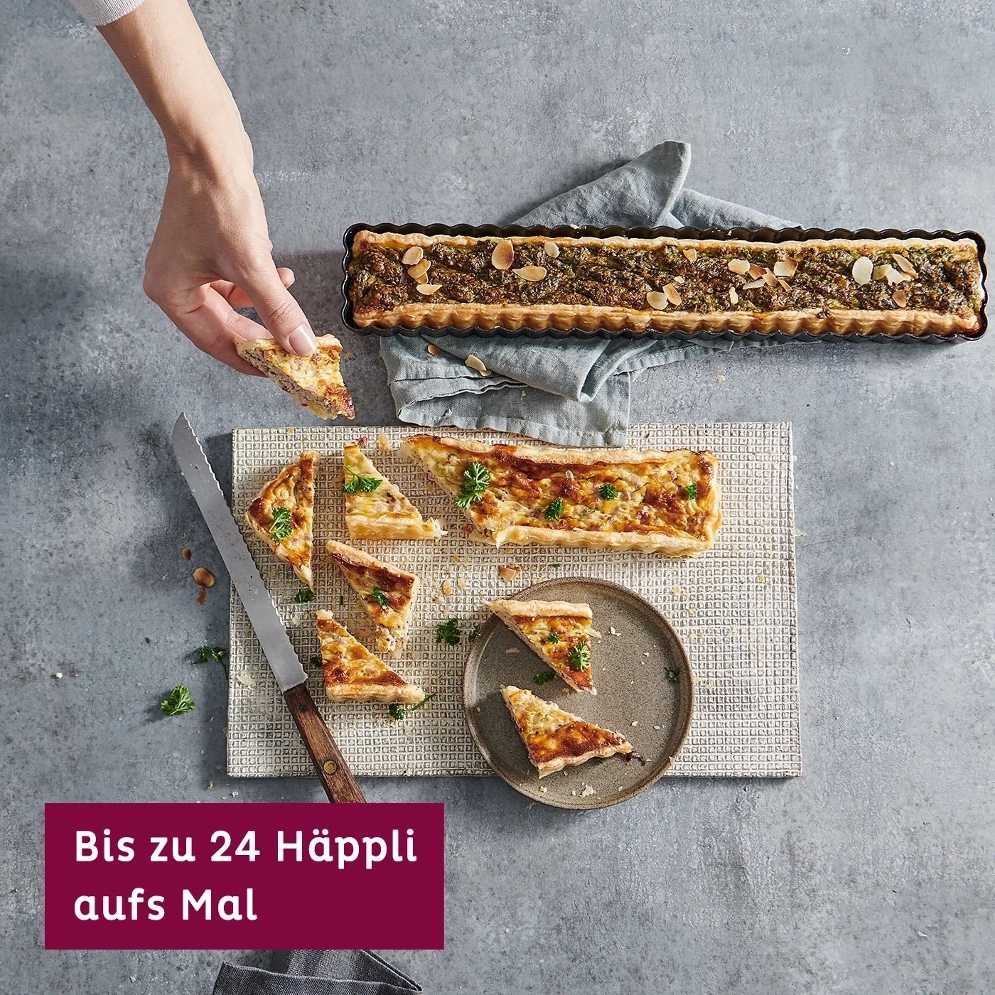 Quiche-Tarte auf Unterlage mit Messer und Teller daneben