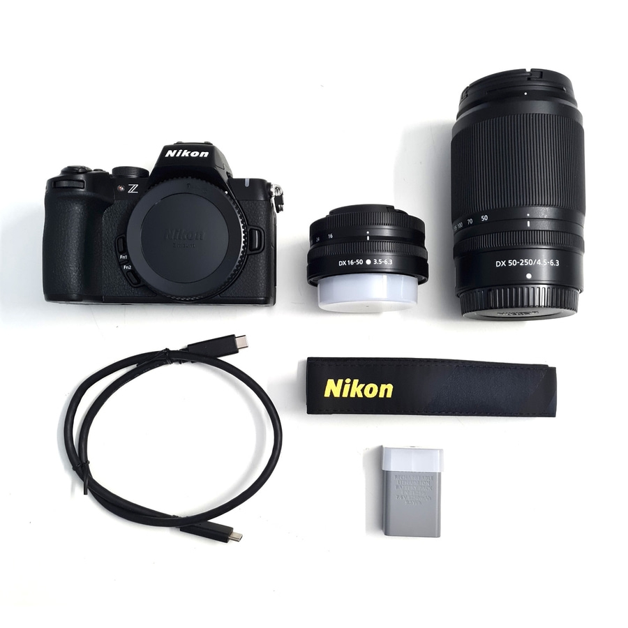 Nikon Kamera mit Zubehör: Objektive, Kabel, Akku und Gurt