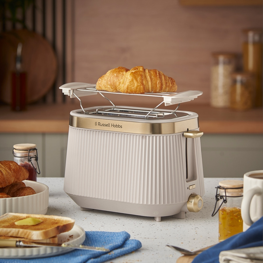 Toaster mit Croissant, Toast und Marmelade auf einem Tisch in der Küche