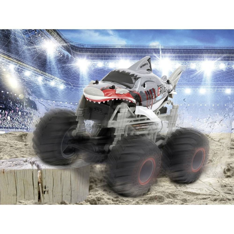 Monster Truck Shark springt über Holzblock vor Stadionkulisse.