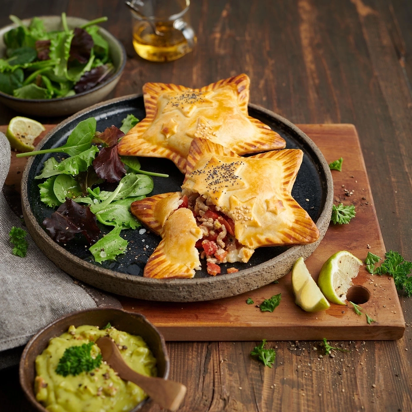 Sternförmige Pasteten mit Salat und Avocado-Dip auf Holzbrett