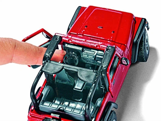 Rotes Spielzeugauto, das geöffnet wird, um das Innere zu zeigen, mit Finger