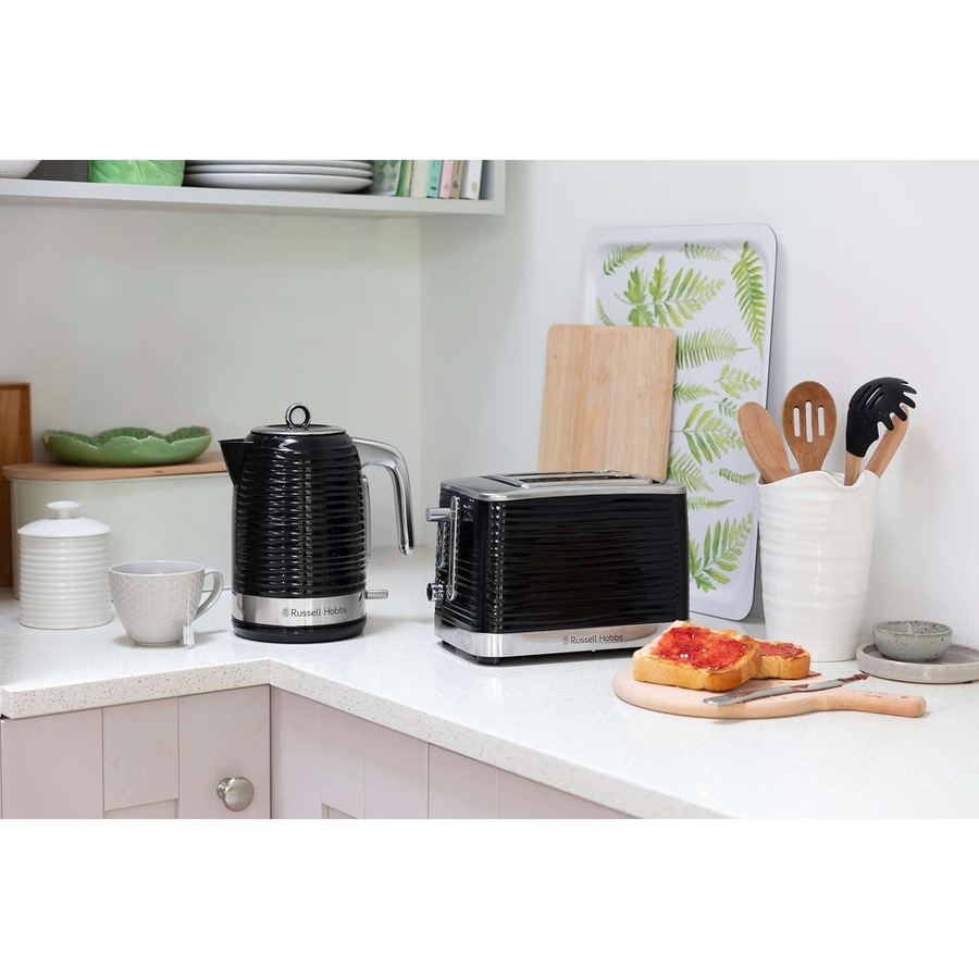 Küche mit Toaster, Wasserkocher, Toast, Utensilien und Dekoration.
