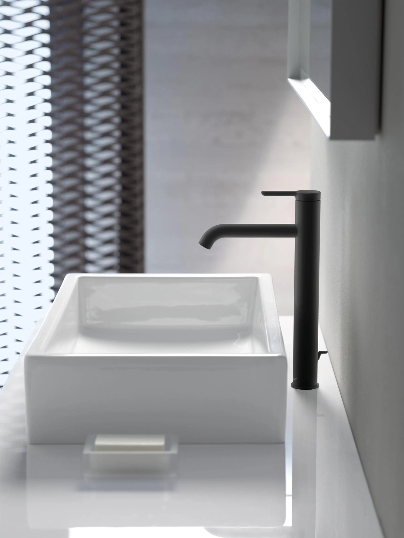 Schwarze Armatur über weißem Waschbecken. Minimalistisches Badezimmer-Design mit Seifenschale.