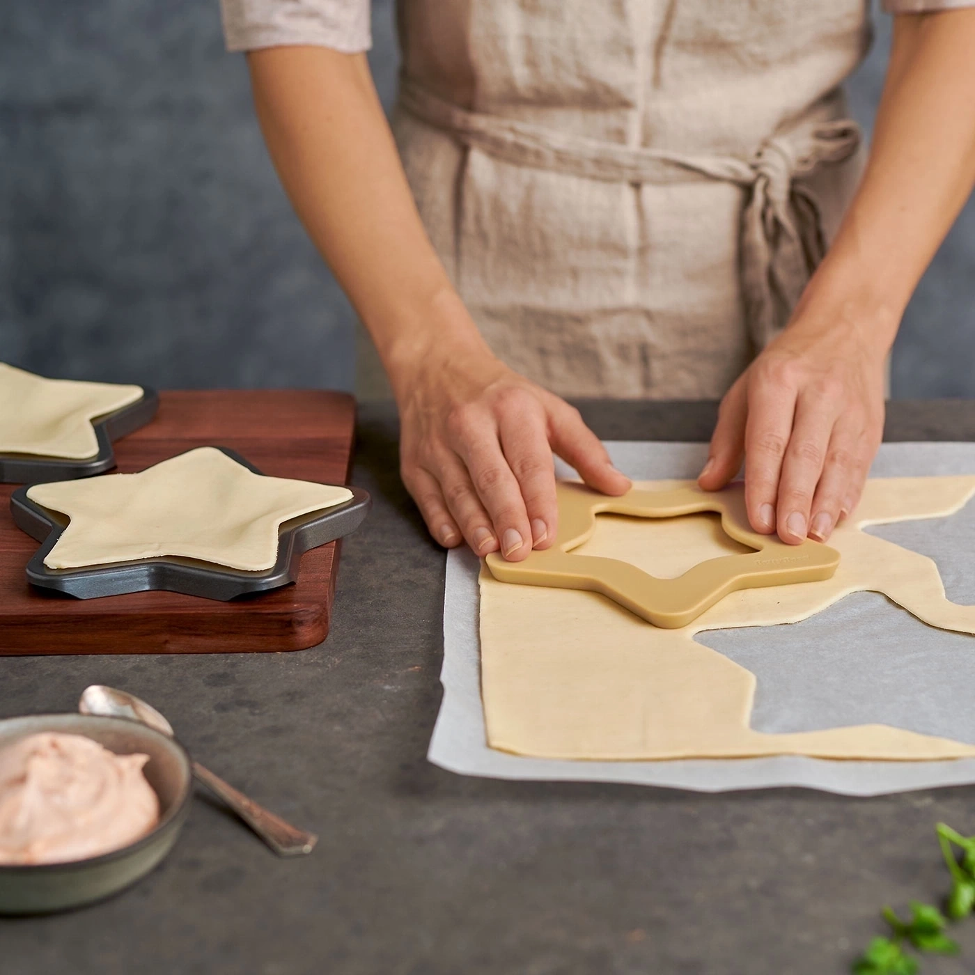 Person schneidet Teig mit Sternform aus. Backen, Küche, Essen zubereiten.