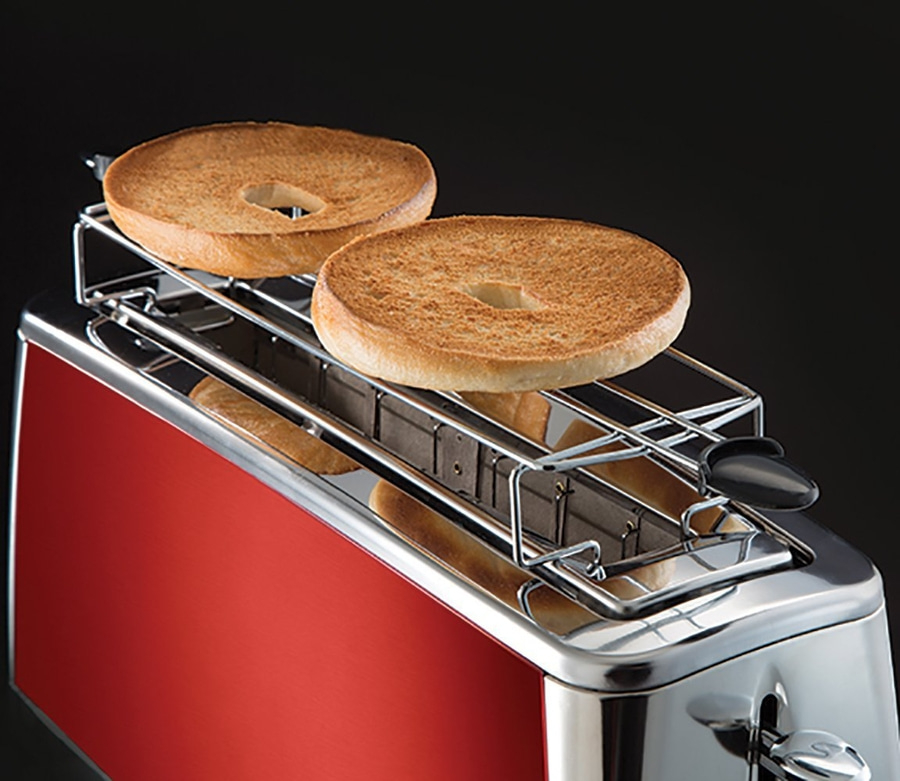 Ein roter Toaster mit zwei gerösteten Bagels auf einem schwarzen Hintergrund.