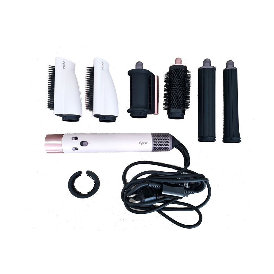 Dyson Airwrap Haarstyling-Set mit verschiedenen Aufsätzen und Zubehör auf weißem Hintergrund