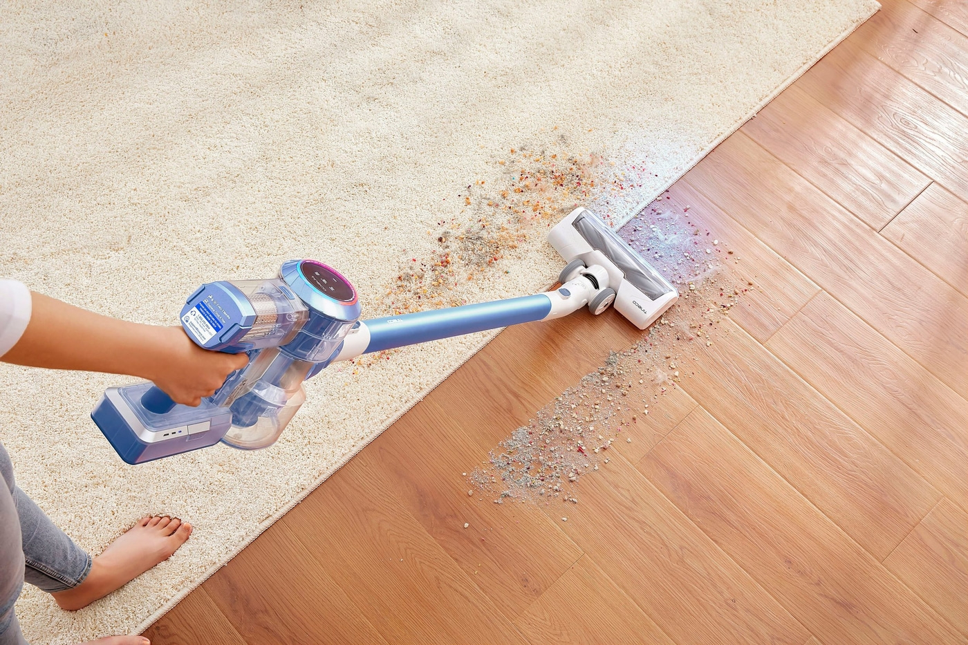 Staubsauger reinigt Teppich und Holzboden. Person saugt mit Staubsauger. Schmutz auf dem Boden.