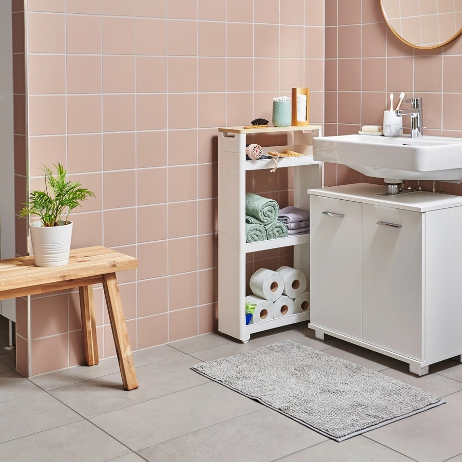 Badezimmer mit Waschbecken, Regal, Handtüchern, Toilettenpapier und Teppich