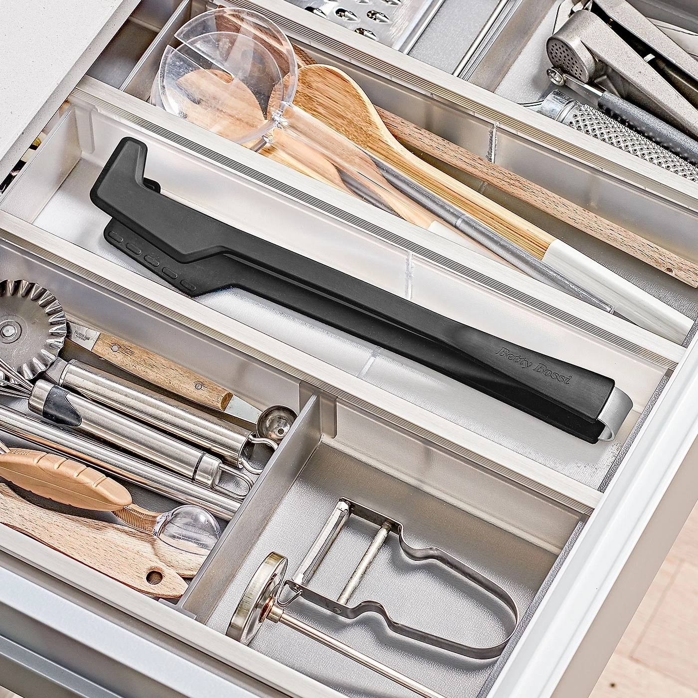 Küchenschublade mit Utensilien: Kochlöffel, Zange, Schäler, etc. Ordnung.
