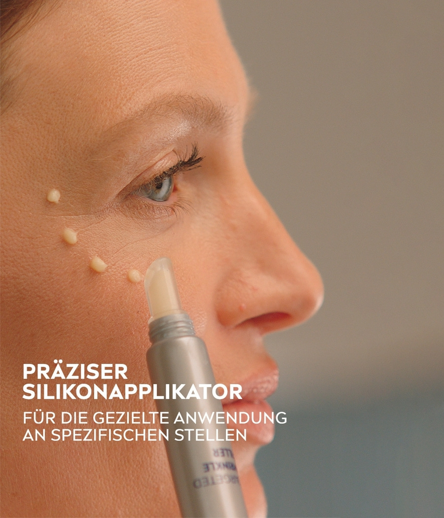 Frau mit Applikator, der Creme auf ihr Gesicht aufträgt, Nahaufnahme