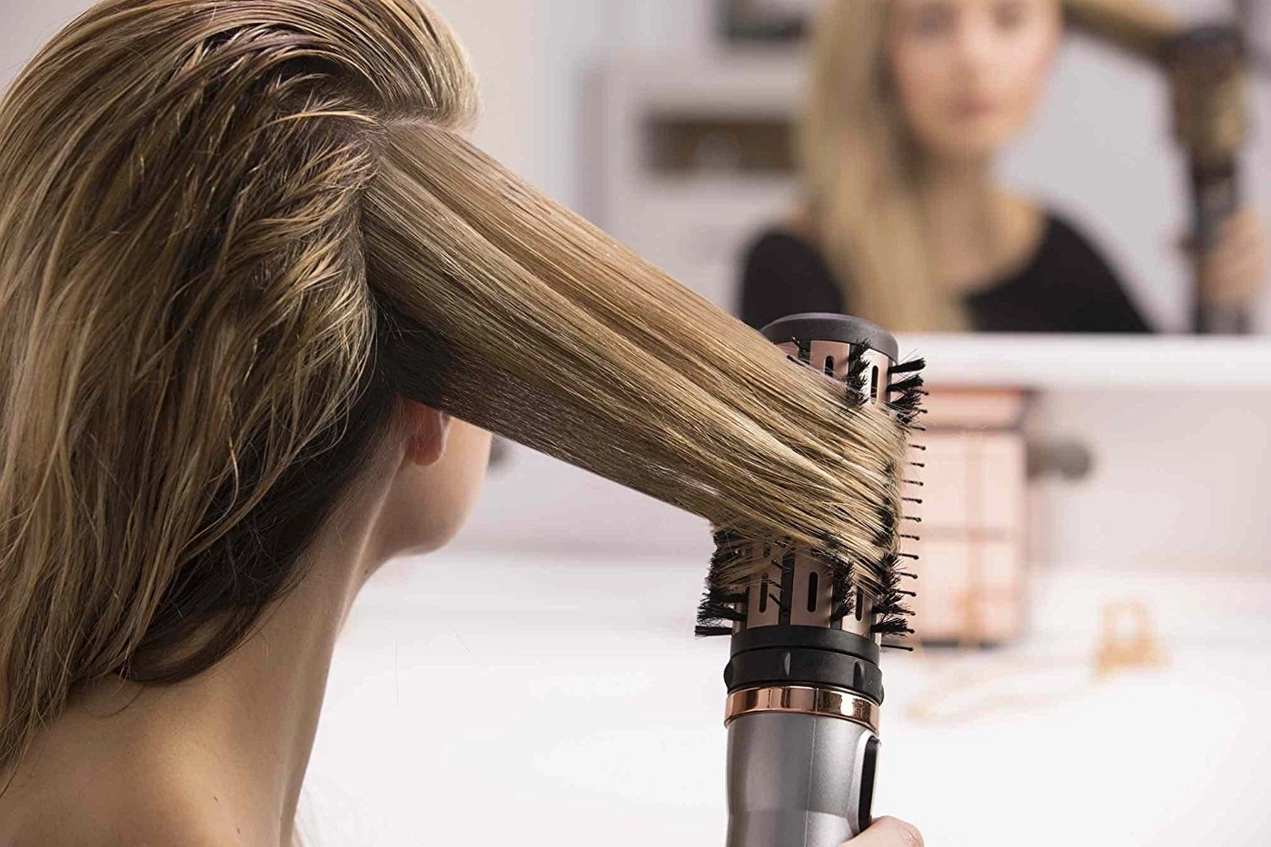 Frau föhnt ihre Haare mit einer Rundbürste, Nahaufnahme, blondes Haar