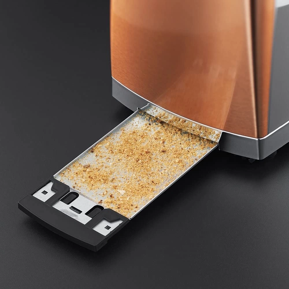 Nahaufnahme eines Toasters mit herausgezogener Krümelschublade, gefüllt mit Krümeln.