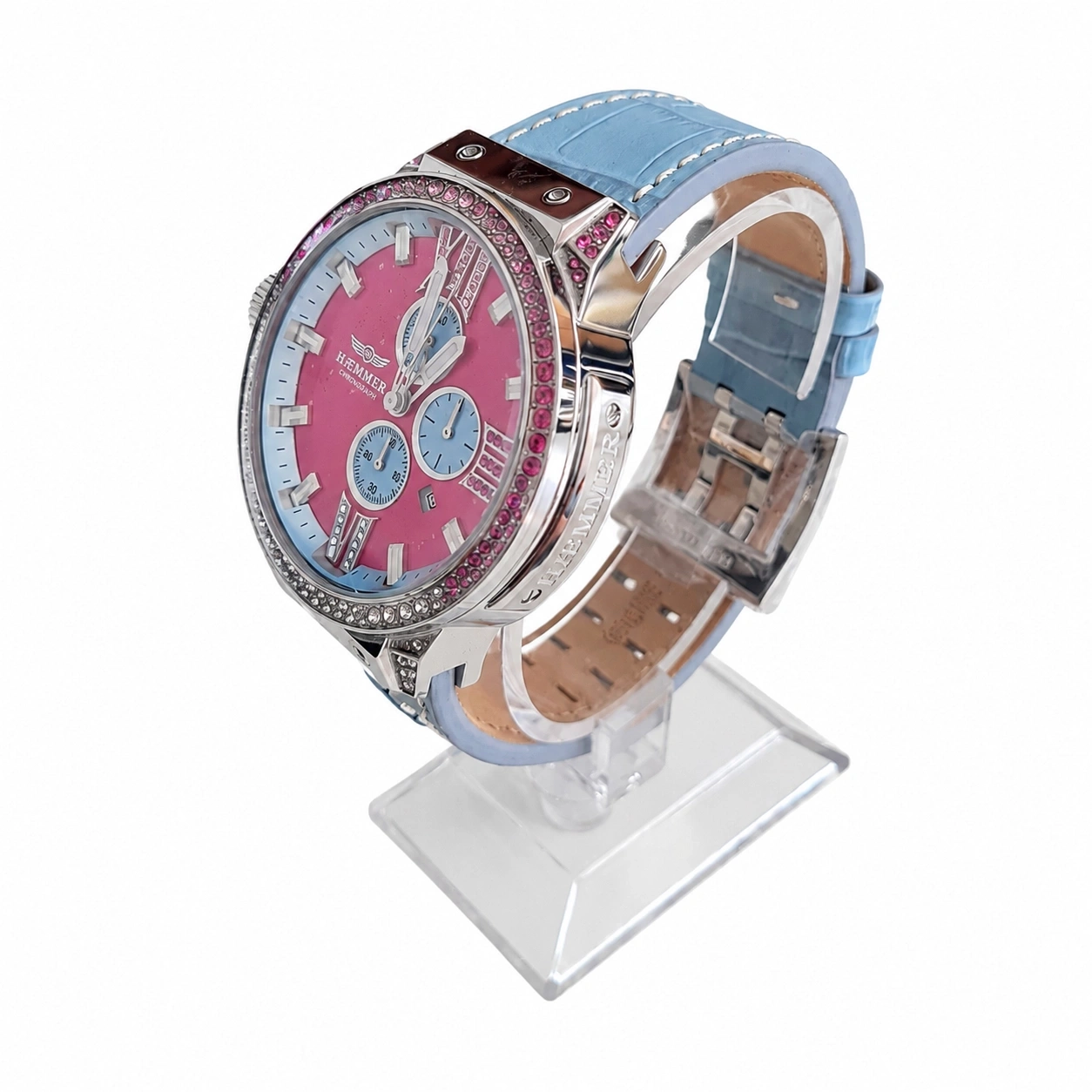 Eine rosafarbene Damenuhr mit blauem Lederarmband und funkelnden Steinen