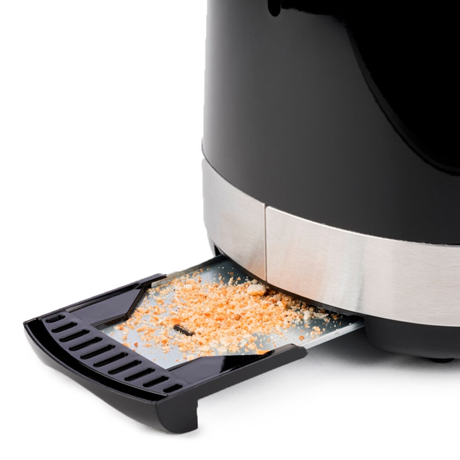 Schwarzer Toaster mit herausnehmbarer Krümelschublade, gefüllt mit Krümeln.