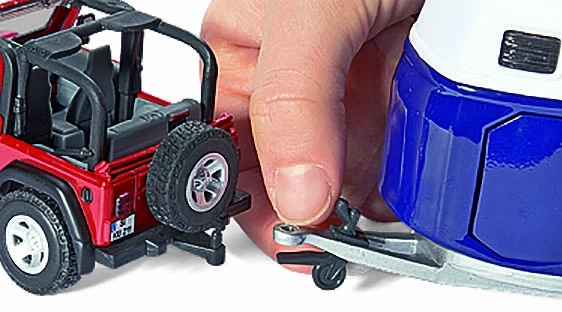 Roter Jeep mit Anhängerkupplung, die mit einem Anhänger verbunden ist.