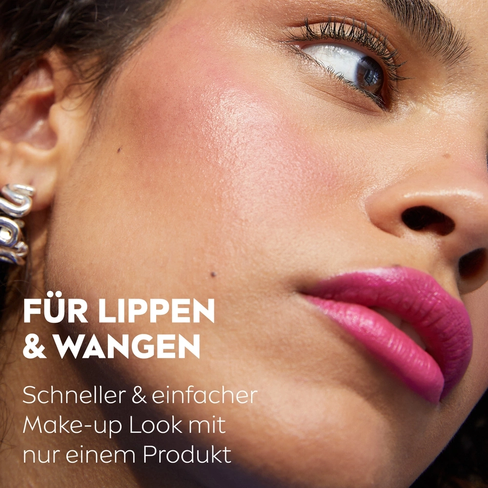 Nahaufnahme einer Frau mit pinkem Lippenstift und Rouge auf den Wangen.