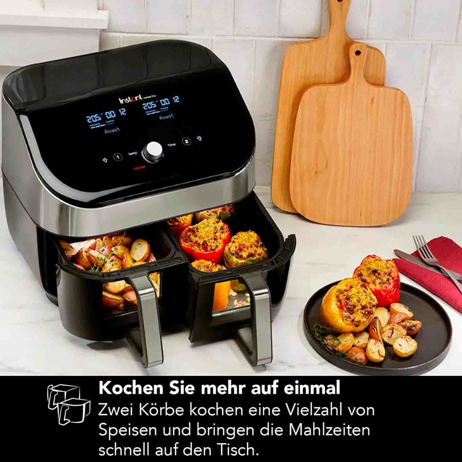 Instant-Luftfritteuse mit zwei Körben und gekochten Speisen, bereit zum Servieren.