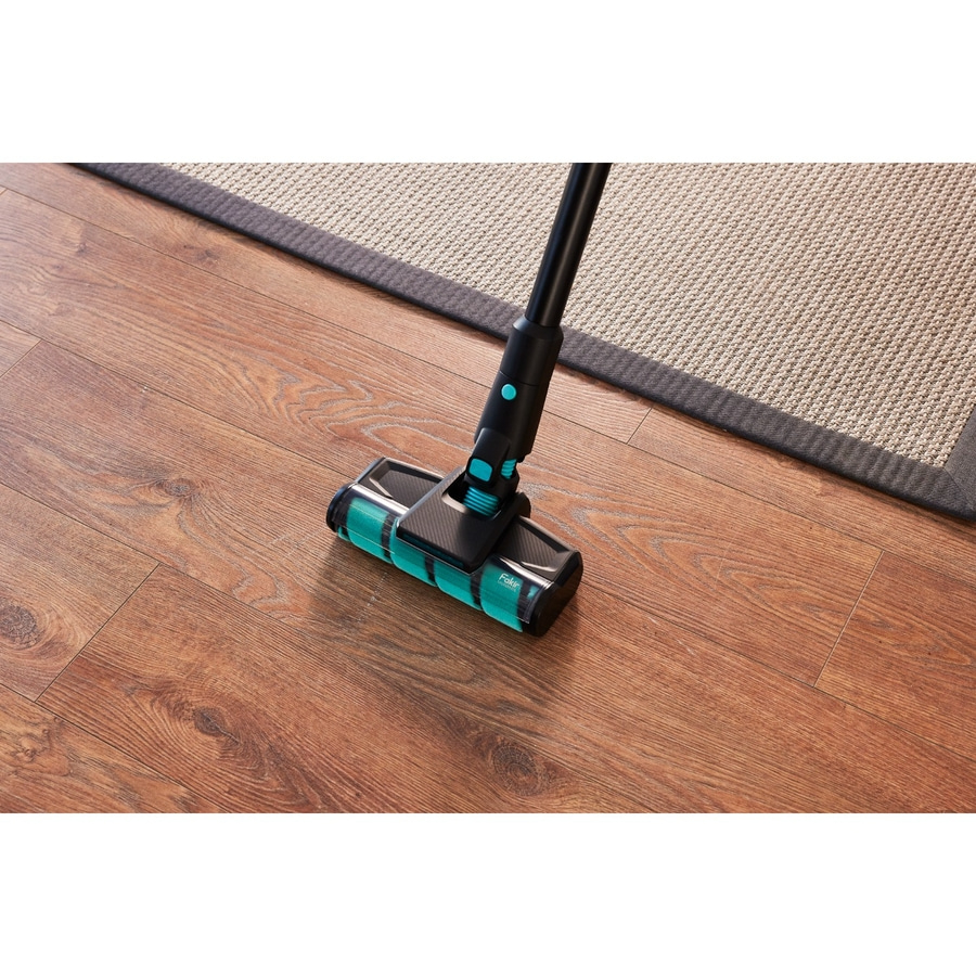 Staubsauger auf Holzboden vor einem Teppich