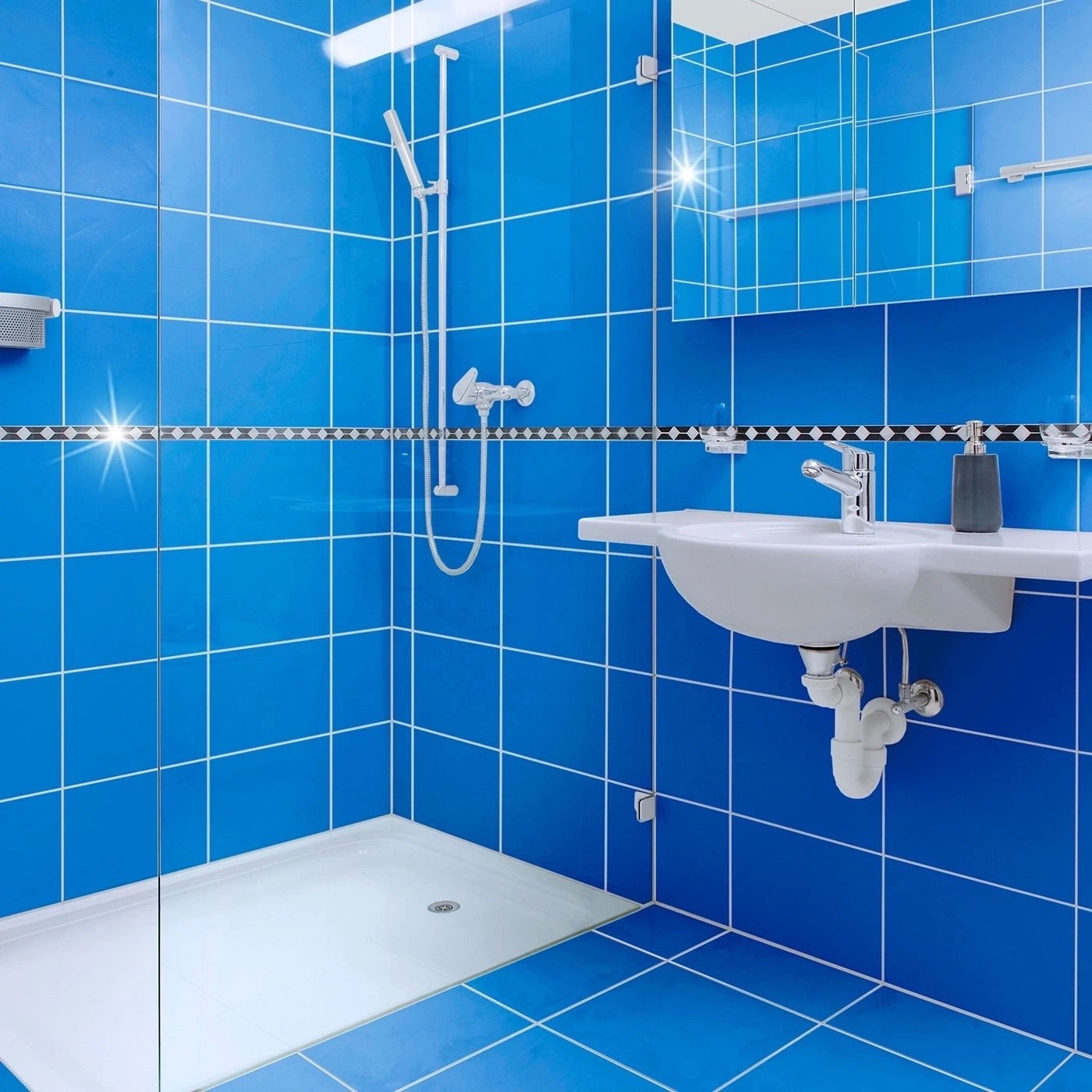 Blau geflieste Badezimmer mit Dusche, Waschbecken und Spiegel. Modernes Design.